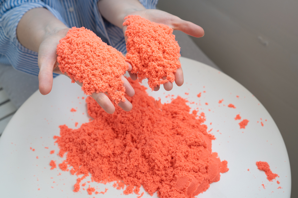hands playing with kinetic sand. development of fine motor skills.